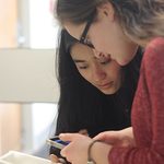Students reverse their negative photo with help from their phone.