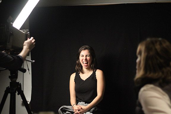 Student laughs getting portrait taken.