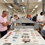 Australian Print Workshop printer Simon White looks on with students at the fantastic array of final editioned work