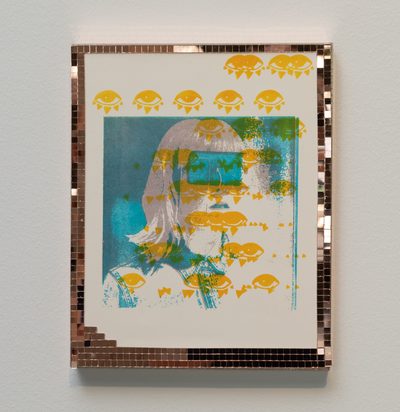 A printed portrait of a blindfolded woman with an overlay of a pattern of eyes, all inside of a frame made of tiny mirrors