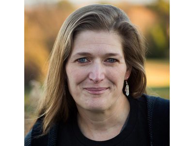 Dr. Julie Reed smiling at the camera wearing a dark crew neck shirt