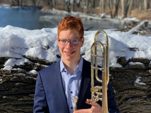 photo of man with red hair holding a trombone