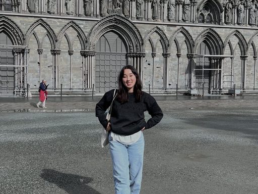 photo of woman standing in front of a gothic church