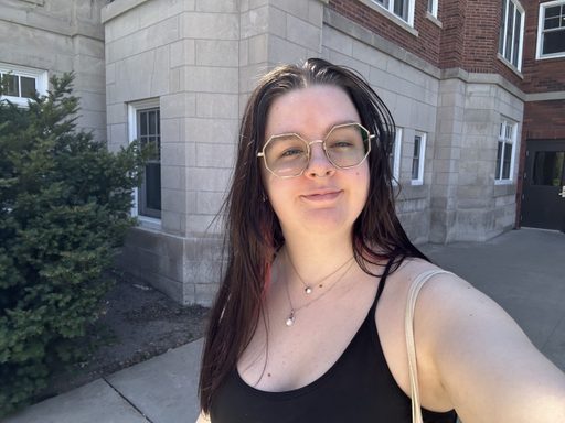 Photo of young woman wearing a black tank top and glasses with gold octagonal frames