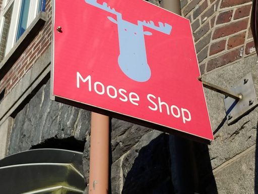 red sign with moose head shape and text