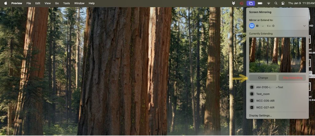 Desktop of Sequoia, with Screen Mirroring menu open.  Menu shows options to Mirror or Extend to, what the current extension is, the buttons Change and Stop MIrroring, 4 display options and at the bottom of the menu the link to Display Settings.  The Change button has a yellow arrow pointing to it for emphasis.