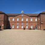 Gressenhall Farm and Workhouse Museum main building. An imposing two-story red brick building under a blue sky.