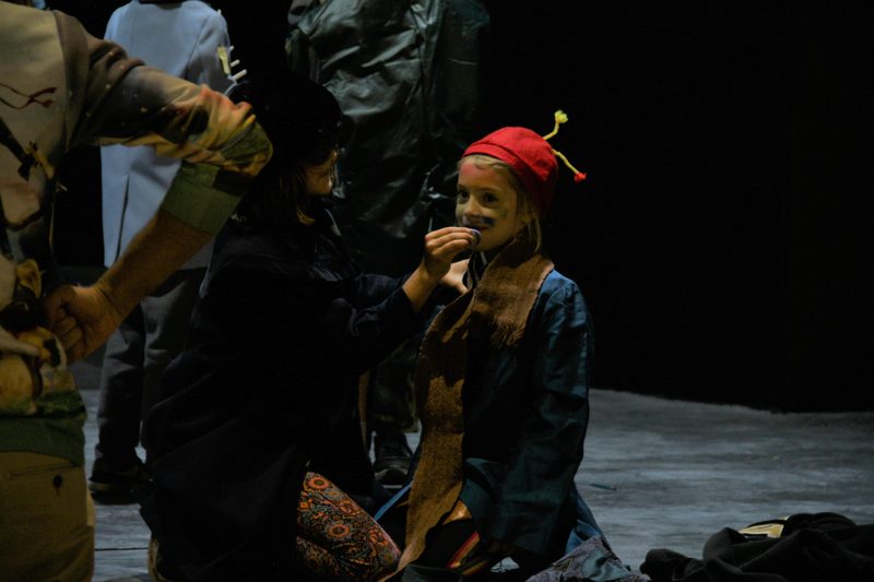 One participant helps another apply face paint.