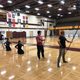 Kyudo Practice. Several students are lined up in a school gym with longbows