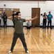 Kyudo Practice. A student draws an arrow as others look on.
