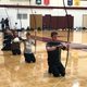 Kyudo Practice. Kyudo learners kneeling in a line with longbows.
