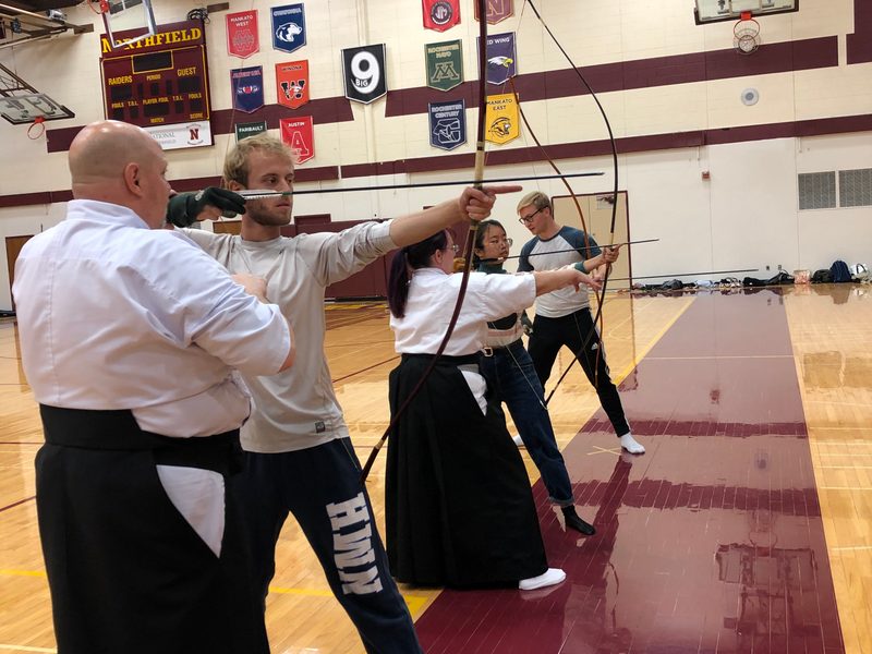 Kyudo Practice. Instructors guide kyudo students with longbows