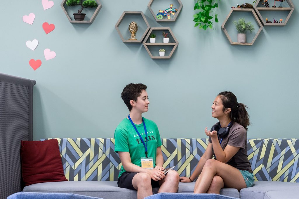 two students sitting on a couch talking in the Language Center