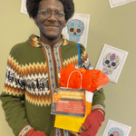Ashton Macklin ('27) posing with prizes won from Día de Muertos trivia!