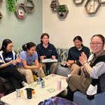 Students laugh around a table, as none of them speak the language the last number was called in