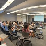 A crowd of students listens to the panel of experts