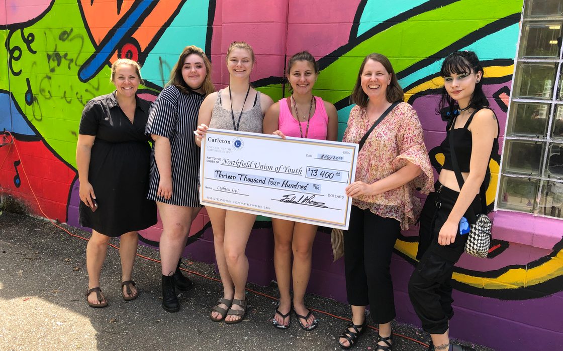 Carleton presents a check for $13,400 to the Northfield Union of Youth