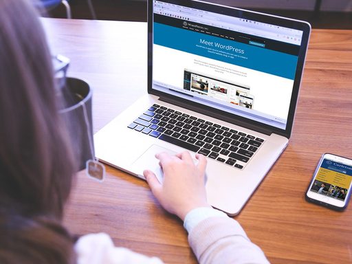 over-the-shoulder view of someone working on a laptop with WordPress on the screen