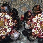 aerial view of students seated around tables eating middle eastern food