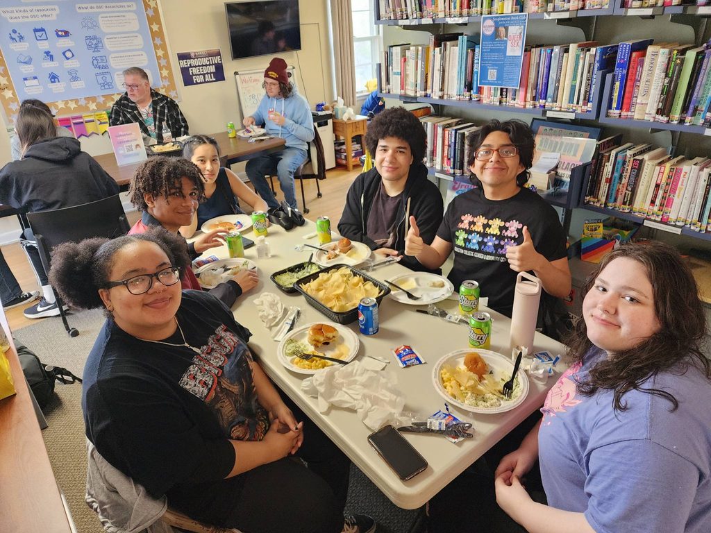 A group of seven students eats at a table.
