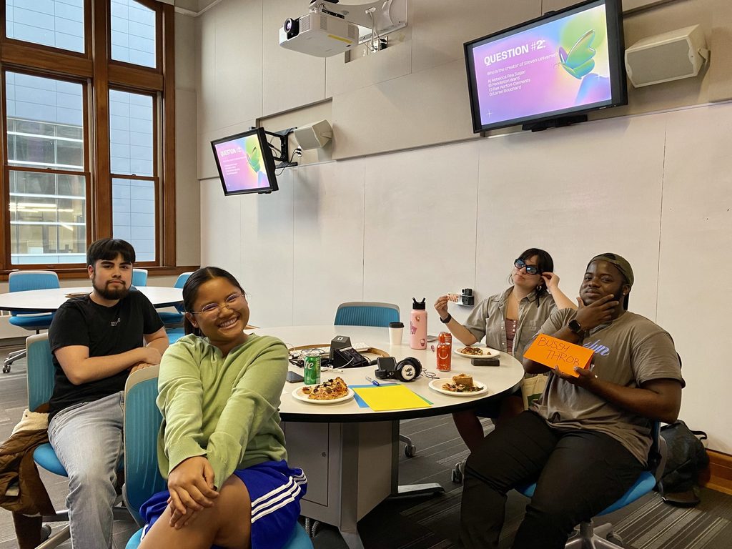 A group of four students attends the Pride Week Trivia Night.