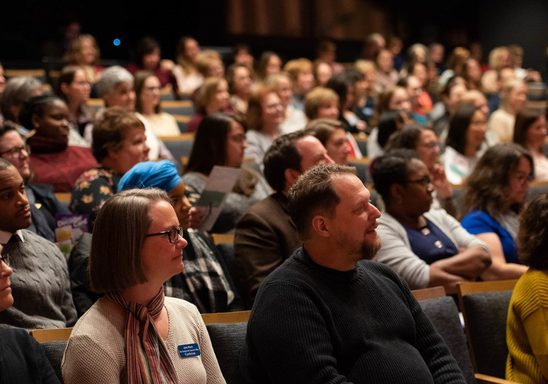 A large crowd of people in an auditorium