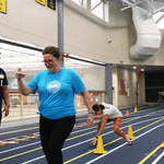 Staff are laughing, an egg in on the ground, and one person is still competing.