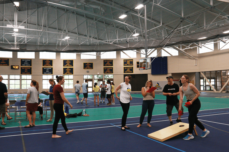People in the recreation center playing corn hole