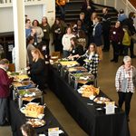 Two buffet lines of food. People standing in line