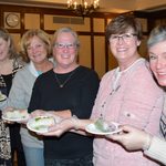 5 people holding a spring roll on a plate
