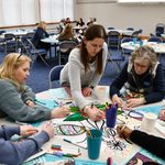 People coloring around a table