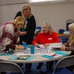 People coloring a large piece of paper