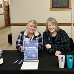 Two people sitting at a welcome table