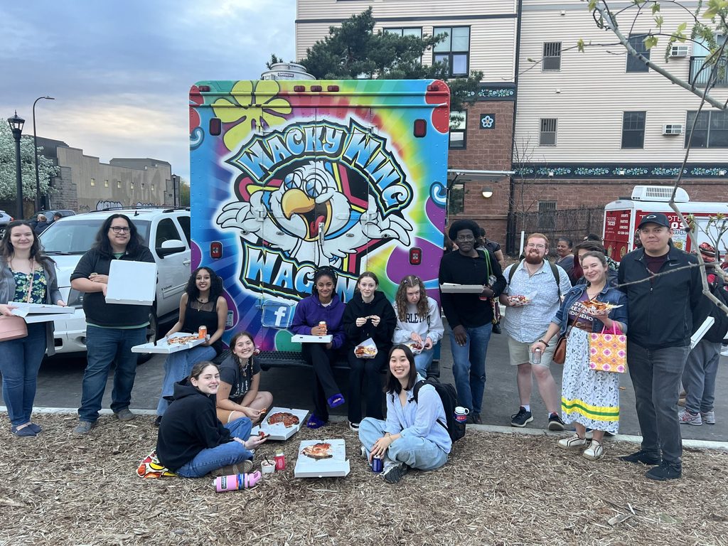 MIAC Openning Event 1 May 2024 Student visitors gathered in front of a food truck celebrating.