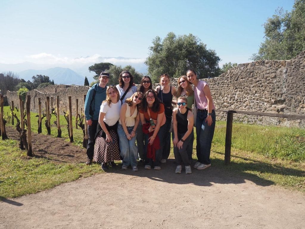 OCS Rome 2025 Students outside on a bright day standing in front of Roman ruins
