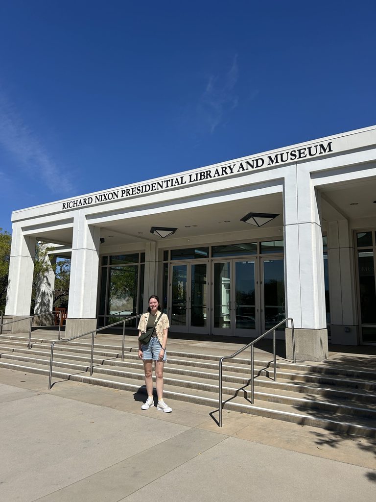 Joella Shearer '26 standing in front of the front doors to the Richard Nixon Presidential Library and Museum