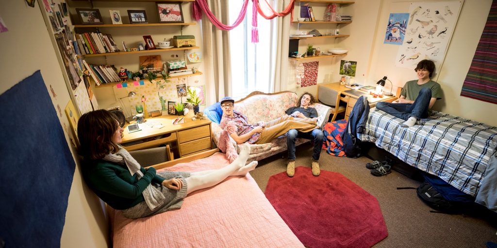 Four students relax in a dorm room