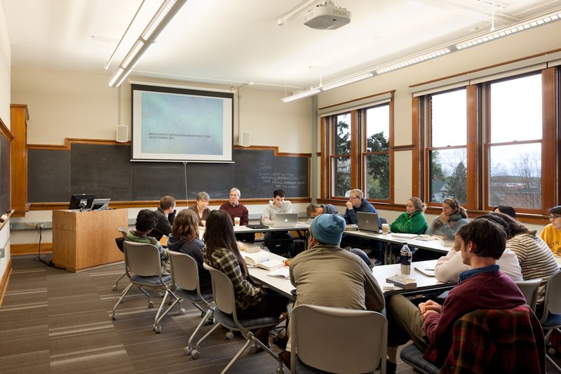 Students sit around a discussion table in a classroom