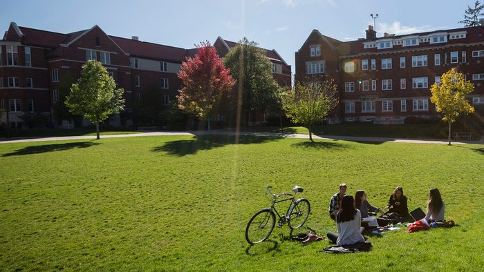 Students sit on the lawn of the Mini Bald Spot