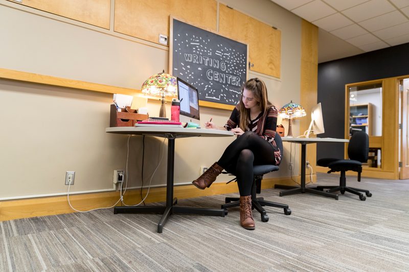 A student works at a computer at the Writing Center