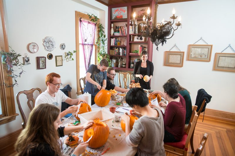 Professor Julia Strand carves pumpkins with her students.