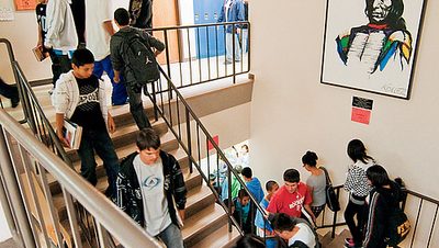 Students pass by a portrait of the school's namesake.