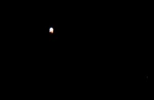 Slightly-less-tiny red and white moon against black sky