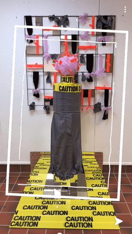 a sculpture with "caution" tape on it
