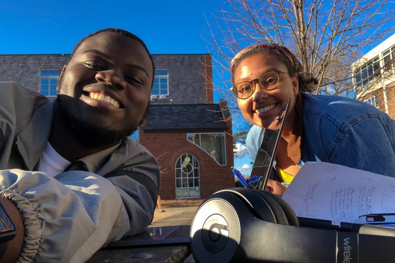 Jevon and Jelimo takes a selfie while doing homework outside.