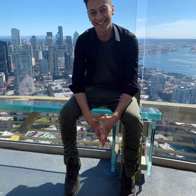 Kellen sits on a bench in a very high skyscraper with a clear glass floor
