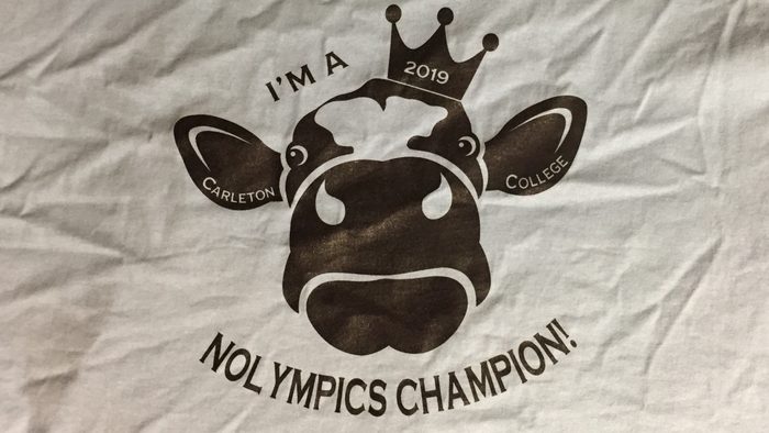 a T-shirt with drawing of a cow and words "I'M A 2019 CARLETON COLLEGE NOLYMPICS CHAMPION!"