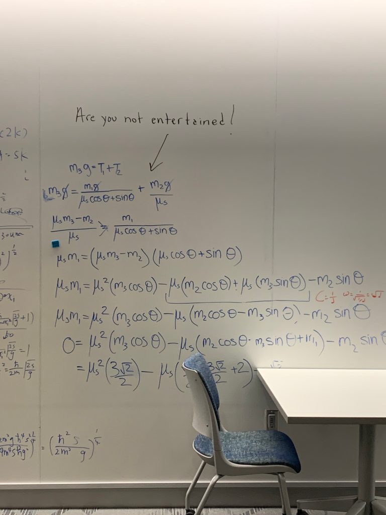 A picture of the Ground State's whiteboard wall with a complex string of math labelled "Are you not entertained!"