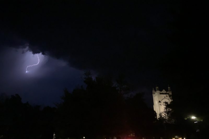 A lightning bolt illuminates the sky to the left of Skinner Memorial Chapel