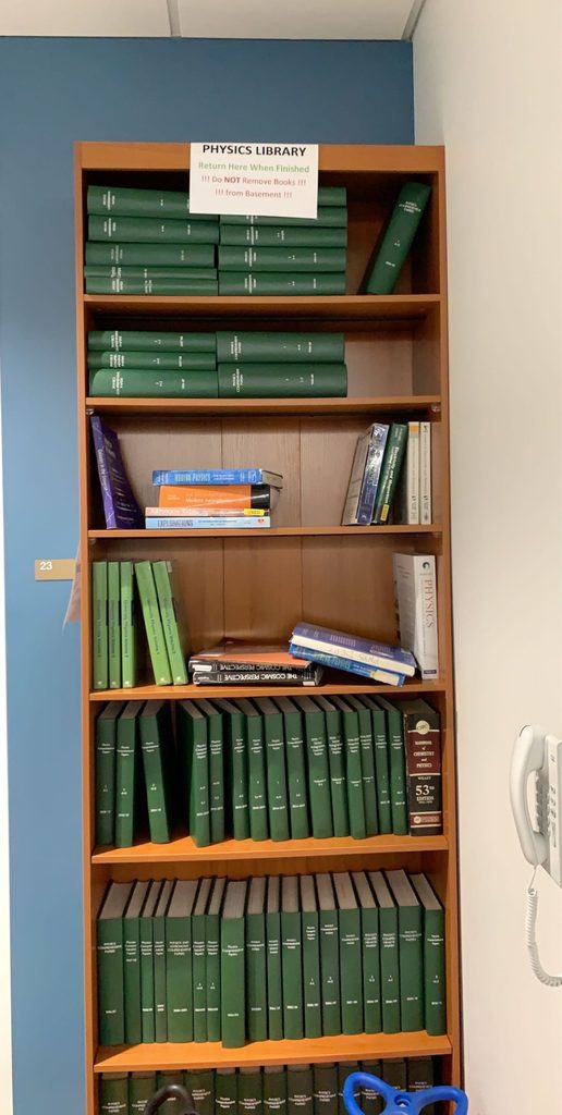 A picture of the Ground State's "physics library" – a multi-tier shelf packed with an assortment of textbooks